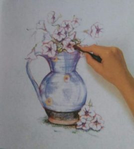 hand adding finishing details to a drawing of flowers in a jug made with colored pencils