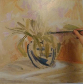 hand sketching flowers in a vase with paintbrush