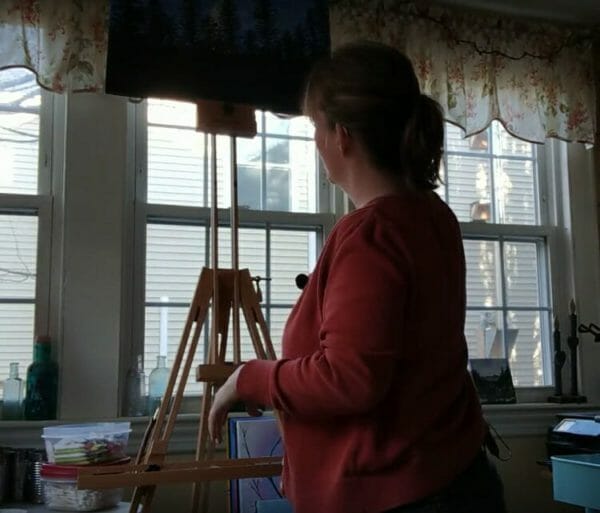 woman painting in front of mon marte field easel