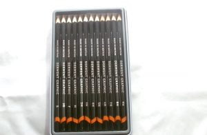 opened box of 12 Derwent graphite pencils on a white background