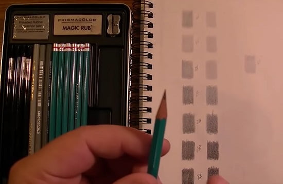 Tone chart of prismacolor premier graphite pencils next to the open box of pencils